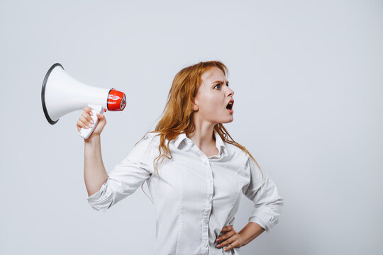 A woman with a megaphone is surprised and annoyed because she is campaigning in the wrong direction. Promotion, action success business with isolated free copy space background.