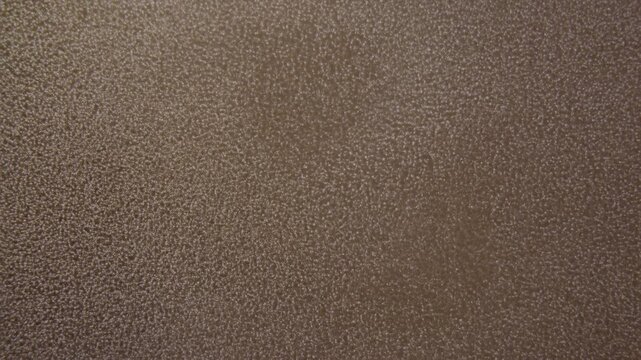 Recording tight brown textured surface, camera capturing subtle light shifts for inspection in lab