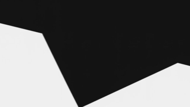 Shifting large black polygon sliding down and left on play in closeup, settling into new alignment