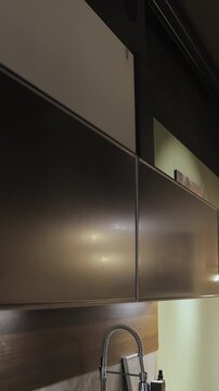 Vertical video. Metal kitchen cabinetry with minimalist design and modern interior details.
