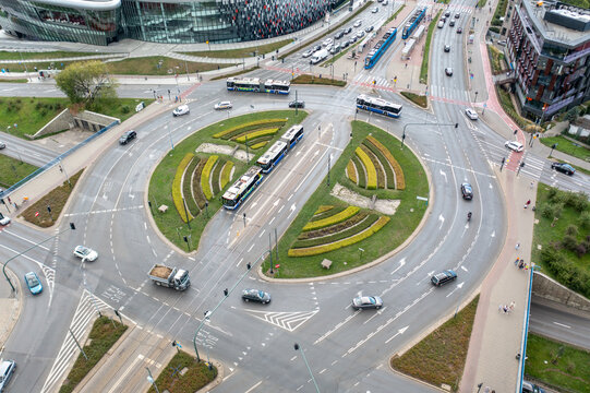 Aerial view of a busy roundabout with trams, buses, and cars navigating the intersection surrounded by urban infrastructure in Krakow, Lesser Poland Voivode, Poland.