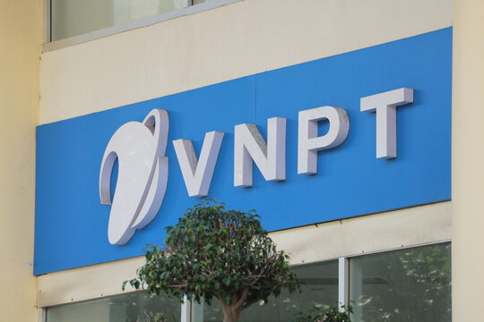 NHA TRANG, VIETNAM - JANUARY 26, 2026: A close-up isolated view of the VNPT corporate logo and sign on a building facade with a fragment of a window and a tree.