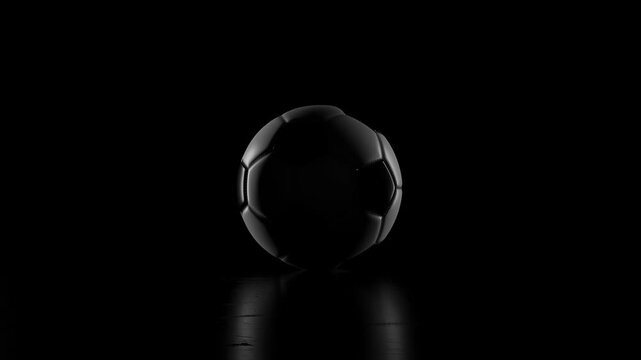 traditional black and white football rotating in low key light