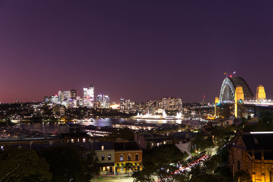 Sydney harbour glowing at night, as seen from Observatory Hill.