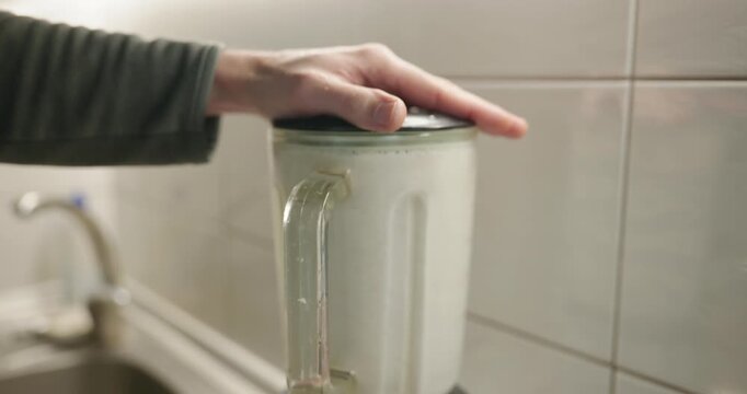Caucasian man makes sauce mixing in blender. Single male is cooking at kitchen at home. 4K 10-bit