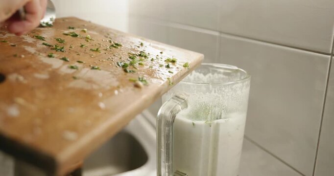 Caucasian man makes sauce mixing in blender. Single male is cooking at kitchen at home. 4K 10-bit