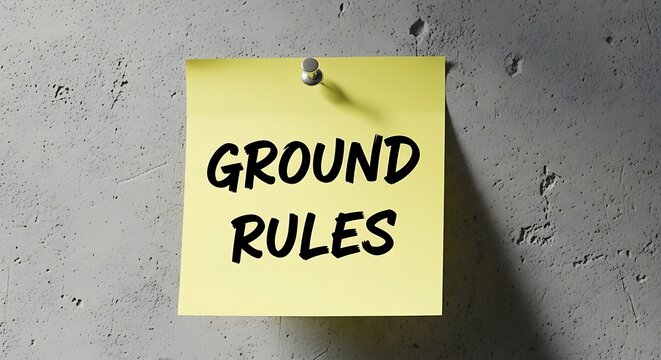 Yellow sticky note with ground rules written in black bold text on wall