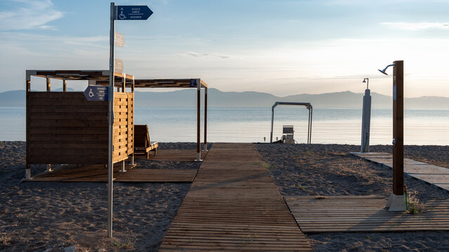 Accessible beach infrastructure with wheelchair friendly facilities, pergola, shower, changing area and sea access system in Greece . Inclusive tourism and barrier-free recreation concept.