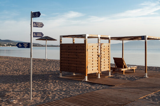 Accessible beach facilities in Greece with changing room, pergola, pathways and directional signs for people with disabilities. Inclusive seaside tourism infrastructure.