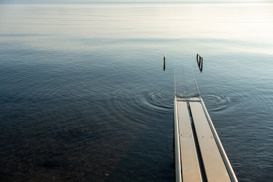 Sea Track rails extending into calm sea water on an accessible beach in Greece, enabling independent swimming access for people with mobility disabilities.