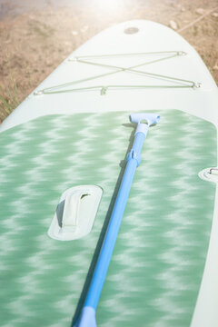 inflatable sup board close up with paddle on surface outdoor background with copy space for banner design concept of water sports travel active tourism summer vacation adventure leisure equipment