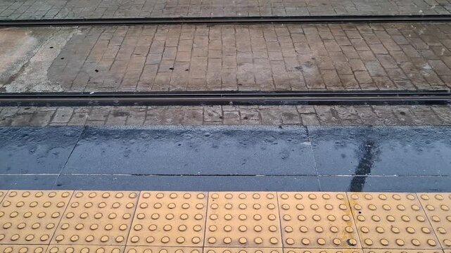 Rain droplets falling on train station floor