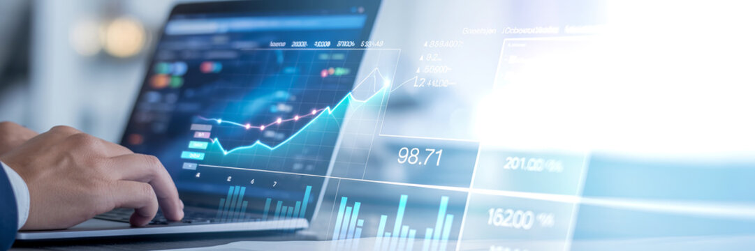 Hands typing on laptop with financial charts and stock market data on screen.