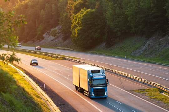 Commercial Box Truck Transporting Goods on Scenic Highway at Sunset