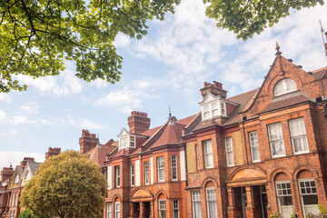 Obraz premium LONDON - red brick terraced houses on residential street with trees