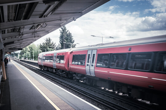 LONDON - red train at suburban railway station platform