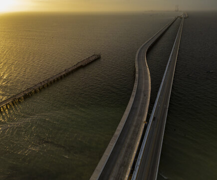 Aerial view of the long bridge and pier at Puerto Progreso stretching into the sea during golden hour in Progreso, Yucatan, Mexico.