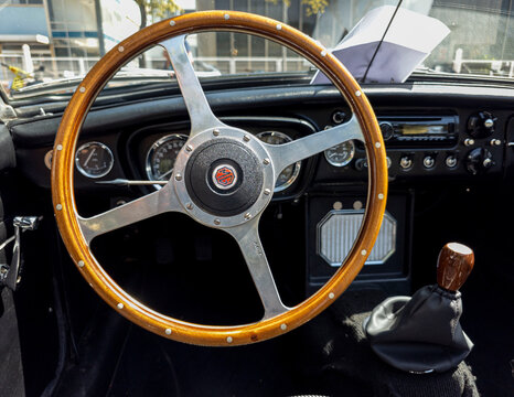 TAVERNES BLANQUES, SPAIN - JUNE 14, 2026.Close up of classic vintage MG MGB sports car interior with wooden steering wheel and dashboard at outdoor auto event