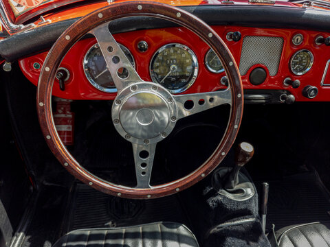 TAVERNES BLANQUES, SPAIN - JUNE 14, 2026.Detailed close up view of vintage wooden steering wheel and retro gauges inside classic MG MGA Roadster sports car