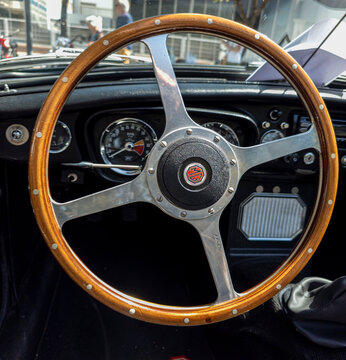 TAVERNES BLANQUES, SPAIN - JUNE 14, 2026.Interior detail shot showing vintage MG MGB sports car with wooden rimmed steering wheel and tachometer gauge