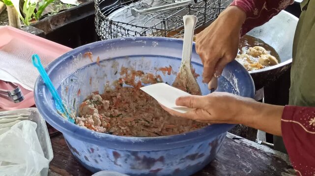 Traditional preparation of fried siomay being cooked and prepared fresh, showcasing Indonesian street food culture and savory culinary traditions.