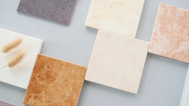 The display includes marble, granite, and ceramic tiles showcasing diverse natural patterns and an elegant pastel color palette&mdash;ranging from crisp white, warm brown, 