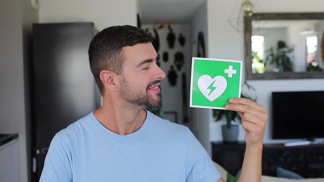 Man holding green and white AED sign showing medical emergency heart symbol