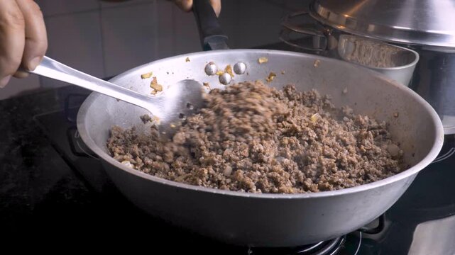 Stirring ground beef cooking in frying pan close up