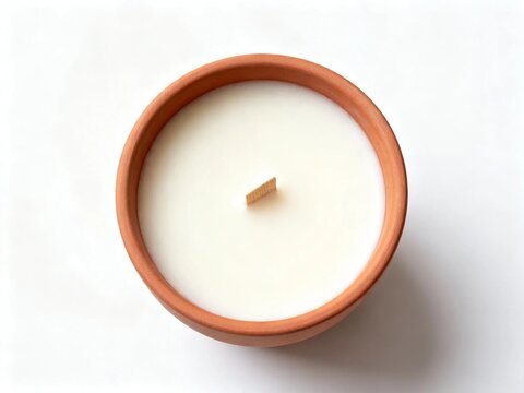 Top-down view of a white candle in a terracotta holder