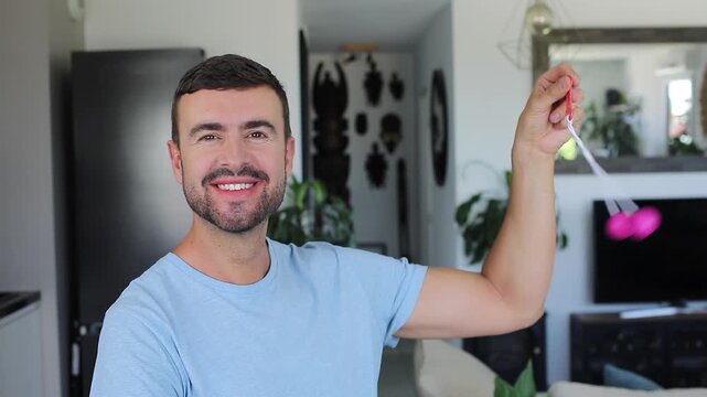 Man Trying To Play With Vintage Clacker Balls Toy Feeling Confused Frustrated