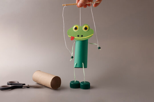 Handmade frog puppet craft made from recycled toilet paper roll. Perfect for kindergarten education, preschool art classes, children creativity blogs, DIY content creators.