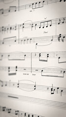 Fototapeta premium Sheet music pages flipping past with chords and notes in soft focus on cream paper, vertical loopable style for music apps, learning content and creative audio promos.