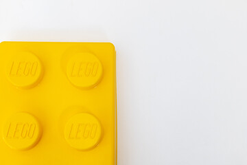 Naklejka premium Bradford, UK June 24 2026 - Close-up of a yellow LEGO storage container lid designed to resemble an ordinary LEGO brick, isolated on a white background with copy space.