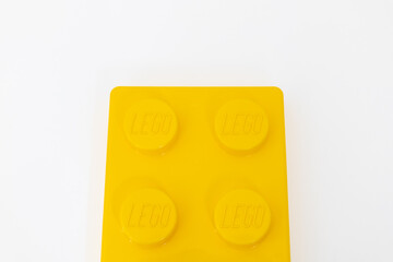 Naklejka premium Bradford, UK June 24 2026 - Close-up of a yellow LEGO storage container lid designed to resemble an ordinary LEGO brick, isolated on a white background with copy space.