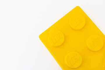 Naklejka premium Bradford, UK June 24 2026 - Close-up of a yellow LEGO storage container lid designed to resemble an ordinary LEGO brick, isolated on a white background with copy space.