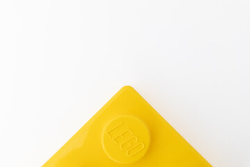 Naklejka premium Bradford, UK June 24 2026 - Close-up of a yellow LEGO storage container lid designed to resemble an ordinary LEGO brick, isolated on a white background with copy space.