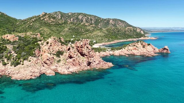 4K drone flight along the Marina di Gairo coastline, featuring Su Sirboni Beach and Cala Laus. Turquoise waters, striking red rocks, and the unspoiled beauty of Sardinia, Italy
