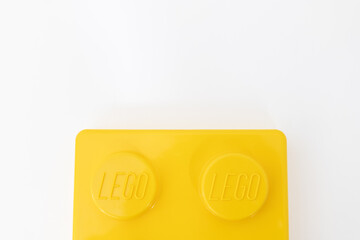 Naklejka premium Bradford, UK June 24 2026 - Close-up of a yellow LEGO storage container lid designed to resemble an ordinary LEGO brick, isolated on a white background with copy space.