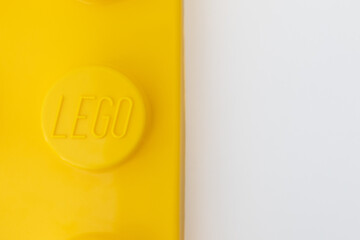 Naklejka premium Bradford, UK June 24 2026 - Close-up of a yellow LEGO storage container lid designed to resemble an ordinary LEGO brick, isolated on a white background with copy space.