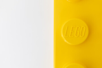 Naklejka premium Bradford, UK June 24 2026 - Close-up of a yellow LEGO storage container lid designed to resemble an ordinary LEGO brick, isolated on a white background with copy space.