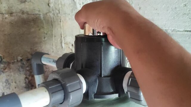 Domestic water filter maintenance process in the backyard during a bright sunny day.