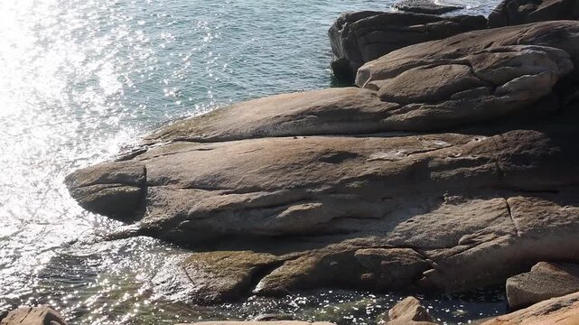 Rocky coastline, with its weathered rock formations and seawater backdrop, shares characteristics with other coastal beach areas featuring distinct rock formations, a tourist attraction in khanom dist