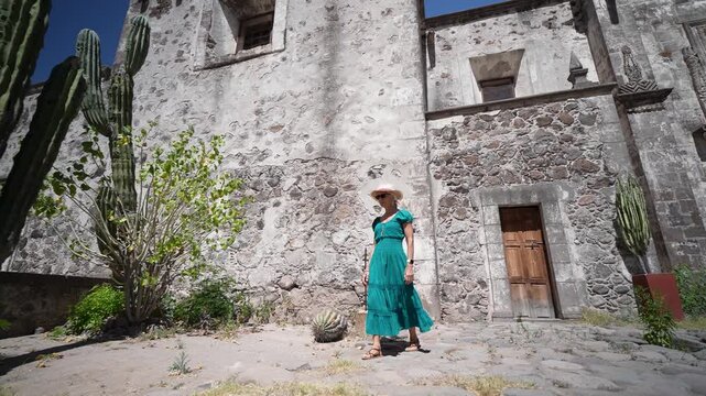 Senior woman enjoys exploring San Javier Mission in Loreto, Baja California Sur at sunrise, taking in the beauty of the desert oasis