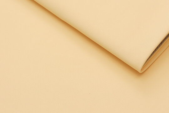 Pastel ye matte crepe fabric texture with a fine, sand-like pebbled grain. High-quality fashion textile material backdrop with an elegant non-reflective surface finish for tailoring and design.