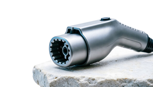 Macro shot of a metal EV charging plug resting on a textured white stone surface, sharp focus, on a white background