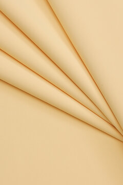 Pastel ye matte crepe fabric texture with a fine, sand-like pebbled grain. High-quality fashion textile material backdrop with an elegant non-reflective surface finish for tailoring and design.