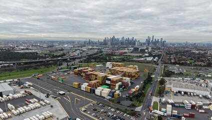 Fototapeta premium Melbourne city skyline rising above industrial shipping containers