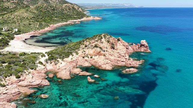 4K drone flight along the Marina di Gairo coastline, featuring Su Sirboni Beach and Cala Laus. Turquoise waters, striking red rocks, and the unspoiled beauty of Sardinia, Italy
