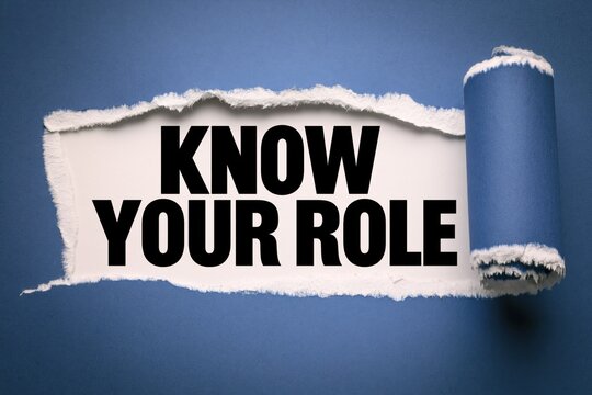 know your role phrase written on white paper under torn blue paper