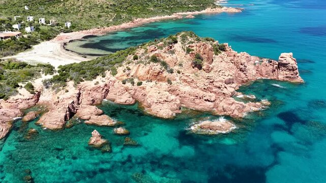 4K drone flight along the Marina di Gairo coastline, featuring Su Sirboni Beach and Cala Laus. Turquoise waters, striking red rocks, and the unspoiled beauty of Sardinia, Italy